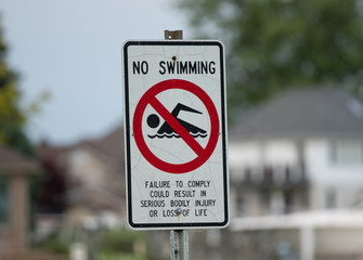 sign is posted and says no swimming