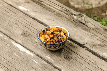 Light and dark raisins in a bowl on a wooden table