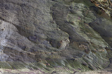 Superfície texturizada de rocha natural, onde se podem linhas desenhadas pelas camadas da rocha formadas ao longo do tempo. Pode ser usado como fundo.
