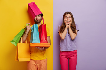 Sad man overloaded with shopping bags, has wife shopaholic, spend free time during weekend on...