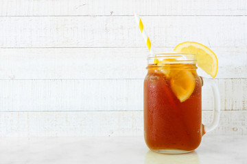 Summer iced tea in a mason jar glass. Side view on a white wood background. - Powered by Adobe