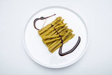 Asperges vertes sur assette blanche en studio