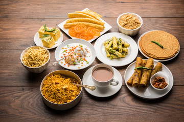 Group of Gujarati snacks like jalebi-fafda, thepla, khaman dhokla, aloo bhujiya, khandvi,khakra, dahi vada, gathiya with hot tea