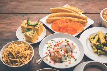 Group of Gujarati snacks like jalebi-fafda, thepla, khaman dhokla, aloo bhujiya, khandvi,khakra, dahi vada, gathiya with hot tea