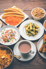 Group of Gujarati snacks like jalebi-fafda, thepla, khaman dhokla, aloo bhujiya, khandvi,khakra, dahi vada, gathiya with hot tea