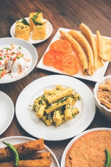 Group of Gujarati snacks like jalebi-fafda, thepla, khaman dhokla, aloo bhujiya, khandvi,khakra, dahi vada, gathiya with hot tea