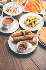 Group of Gujarati snacks like jalebi-fafda, thepla, khaman dhokla, aloo bhujiya, khandvi,khakra, dahi vada, gathiya with hot tea