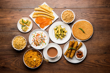 Group of Gujarati snacks like jalebi-fafda, thepla, khaman dhokla, aloo bhujiya, khandvi,khakra, dahi vada, gathiya with hot tea