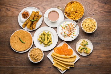Group of Gujarati snacks like jalebi-fafda, thepla, khaman dhokla, aloo bhujiya, khandvi,khakra, dahi vada, gathiya with hot tea