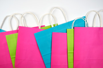 multi-colored paper shopping bags with white handles