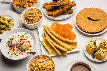 Group of Gujarati snacks like jalebi-fafda, thepla, khaman dhokla, aloo bhujiya, khandvi,khakra, dahi vada, gathiya with hot tea