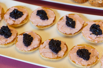 Blinis with taramasalata and lump-fish roe on a white dish