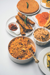 Group of Gujarati snacks like jalebi-fafda, thepla, khaman dhokla, aloo bhujiya, khandvi,khakra, dahi vada, gathiya with hot tea