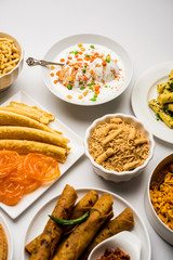 Group of Gujarati snacks like jalebi-fafda, thepla, khaman dhokla, aloo bhujiya, khandvi,khakra, dahi vada, gathiya with hot tea