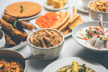 Group of Gujarati snacks like jalebi-fafda, thepla, khaman dhokla, aloo bhujiya, khandvi,khakra, dahi vada, gathiya with hot tea