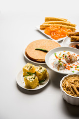 Group of Gujarati snacks like jalebi-fafda, thepla, khaman dhokla, aloo bhujiya, khandvi,khakra, dahi vada, gathiya with hot tea