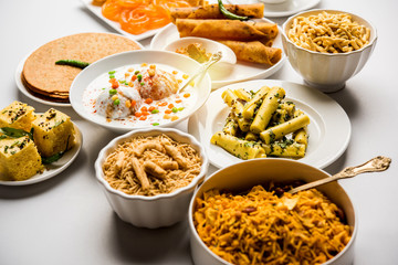 Group of Gujarati snacks like jalebi-fafda, thepla, khaman dhokla, aloo bhujiya, khandvi,khakra, dahi vada, gathiya with hot tea