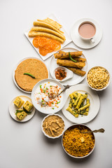Group of Gujarati snacks like jalebi-fafda, thepla, khaman dhokla, aloo bhujiya, khandvi,khakra, dahi vada, gathiya with hot tea