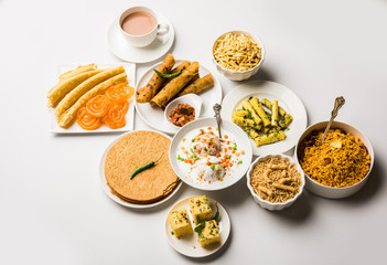 Group of Gujarati snacks like jalebi-fafda, thepla, khaman dhokla, aloo bhujiya, khandvi,khakra, dahi vada, gathiya with hot tea