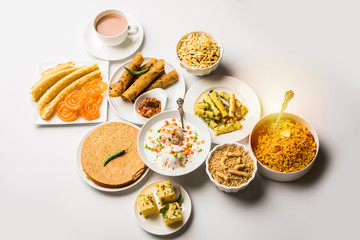 Group of Gujarati snacks like jalebi-fafda, thepla, khaman dhokla, aloo bhujiya, khandvi,khakra, dahi vada, gathiya with hot tea