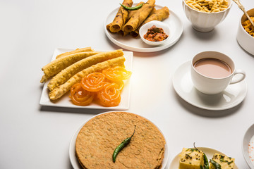 Group of Gujarati snacks like jalebi-fafda, thepla, khaman dhokla, aloo bhujiya, khandvi,khakra, dahi vada, gathiya with hot tea
