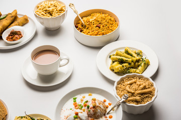 Group of Gujarati snacks like jalebi-fafda, thepla, khaman dhokla, aloo bhujiya, khandvi,khakra, dahi vada, gathiya with hot tea