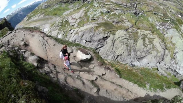 Adult mother with pre teen daughter hiking to the Trolltunga natural attraction in mountains. Norway