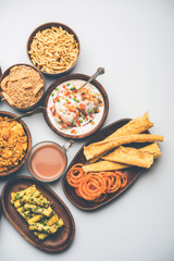 Group of Gujarati snacks like jalebi-fafda, thepla, khaman dhokla, aloo bhujiya, khandvi,khakra, dahi vada, gathiya with hot tea