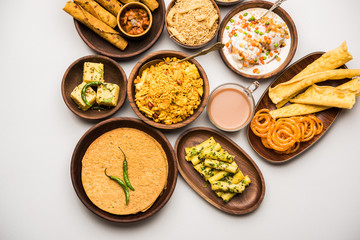 Group of Gujarati snacks like jalebi-fafda, thepla, khaman dhokla, aloo bhujiya, khandvi,khakra, dahi vada, gathiya with hot tea