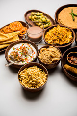 Group of Gujarati snacks like jalebi-fafda, thepla, khaman dhokla, aloo bhujiya, khandvi,khakra, dahi vada, gathiya with hot tea