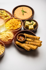 Group of Gujarati snacks like jalebi-fafda, thepla, khaman dhokla, aloo bhujiya, khandvi,khakra, dahi vada, gathiya with hot tea