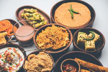 Group of Gujarati snacks like jalebi-fafda, thepla, khaman dhokla, aloo bhujiya, khandvi,khakra, dahi vada, gathiya with hot tea