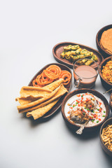 Group of Gujarati snacks like jalebi-fafda, thepla, khaman dhokla, aloo bhujiya, khandvi,khakra, dahi vada, gathiya with hot tea