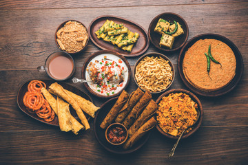 Group of Gujarati snacks like jalebi-fafda, thepla, khaman dhokla, aloo bhujiya, khandvi,khakra, dahi vada, gathiya with hot tea