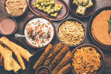 Group of Gujarati snacks like jalebi-fafda, thepla, khaman dhokla, aloo bhujiya, khandvi,khakra, dahi vada, gathiya with hot tea