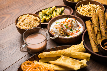 Group of Gujarati snacks like jalebi-fafda, thepla, khaman dhokla, aloo bhujiya, khandvi,khakra, dahi vada, gathiya with hot tea