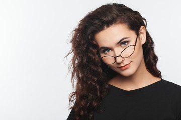 Portrait of a beautiful intelligent woman with curly hair and spectacles. Studio photo session