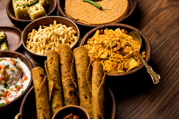 Group of Gujarati snacks like jalebi-fafda, thepla, khaman dhokla, aloo bhujiya, khandvi,khakra, dahi vada, gathiya with hot tea