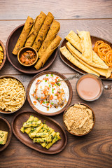 Group of Gujarati snacks like jalebi-fafda, thepla, khaman dhokla, aloo bhujiya, khandvi,khakra, dahi vada, gathiya with hot tea