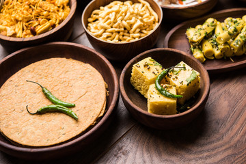 Group of Gujarati snacks like jalebi-fafda, thepla, khaman dhokla, aloo bhujiya, khandvi,khakra, dahi vada, gathiya with hot tea