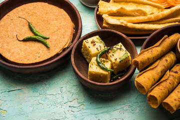 Group of Gujarati snacks like jalebi-fafda, thepla, khaman dhokla, aloo bhujiya, khandvi,khakra, dahi vada, gathiya with hot tea