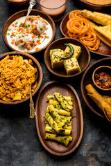 Group of Gujarati snacks like jalebi-fafda, thepla, khaman dhokla, aloo bhujiya, khandvi,khakra, dahi vada, gathiya with hot tea
