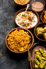 Group of Gujarati snacks like jalebi-fafda, thepla, khaman dhokla, aloo bhujiya, khandvi,khakra, dahi vada, gathiya with hot tea