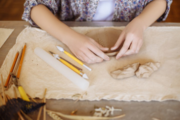 Obraz na płótnie Canvas female hands make a plate of clay