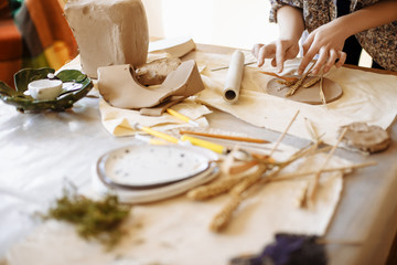 female hands make a plate of clay
