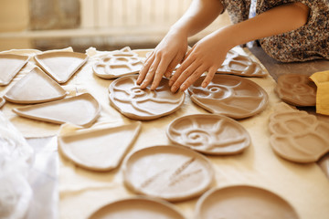 female hands set up clay plates