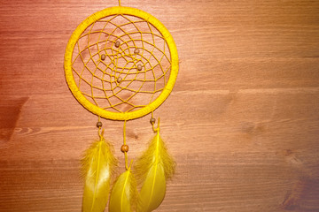 round homemade amulet for catching dreams woven from threads on a wooden