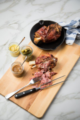 Gegrilltes Schweinefleisch Haxen Fleisch auf Holzbrett mit Cornichons, süßen und mittelscharfen...