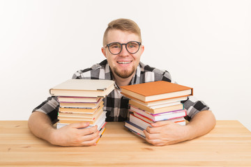 People, knowledge and education concept - Guy sitting hugging a book at the wooden table