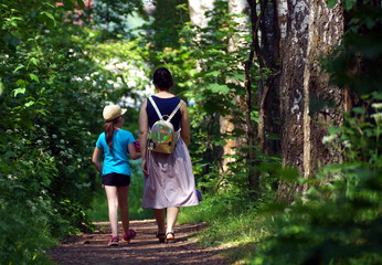 Naklejka na ściany i meble mother and daughter walking in the park